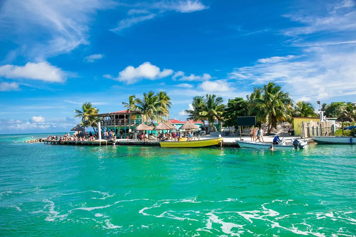 Muelle con palapas y aguas turquesa en la costa de Belice